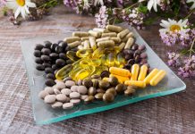 Image of a collection of menopause supplements on a glass dish surrounded by flowers