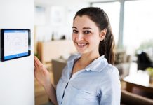 Image of a woman explaining what is a smart meter showing the temperature of the room on screen