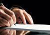 Human hand signing a probate form for article on what is probate