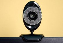 Image of a wifi security camera shown balancing on top of a monitor
