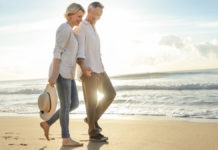 Mature couple on beach to illustrate how much do I need to retire?