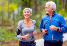 Exercise in autumn and winter: Smiling mature couple jogging in the park