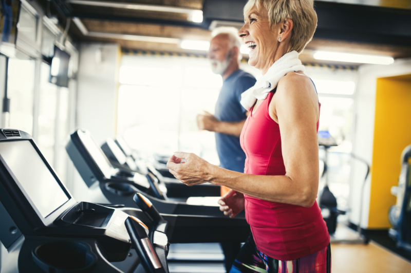 Mature people running in machine treadmill at fitness gym club