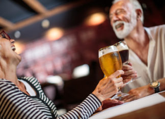 How to cure a hangover quickly senior couple in a pub drinking beer and wine.