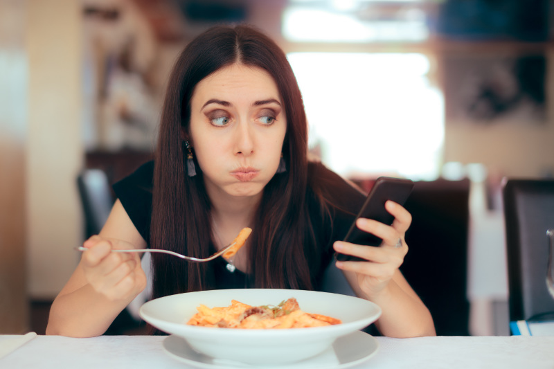 Diet mistakes Technology addict using Smartphone in the meal time