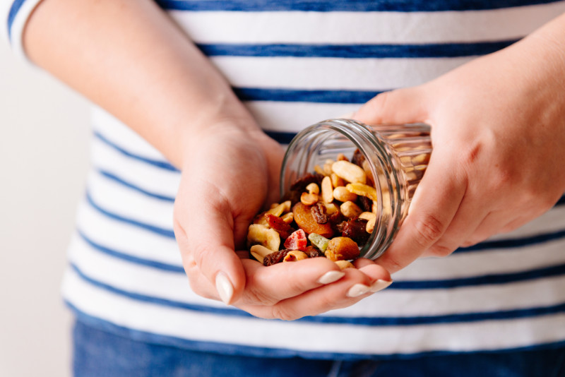 Hands holding a jar of nuts and dried fruits. Healthy breakfast. Sweet and healthy food, snack