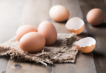 How to crack an egg raw fresh egg on sack and wood background