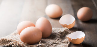 How to crack an egg raw fresh egg on sack and wood background