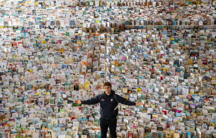 Captain Tom Moore’s grandson Benjie surrounded by 100th birthday cards (Joe Giddens/PA)