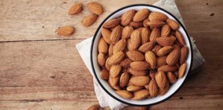 Health benefits of almonds White bowl of almonds on wooden background