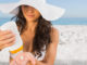 Skin cancer facts Woman applying sun cream on the beach