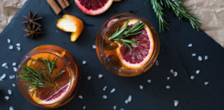 Aperitivo cocktail served with a slice of orange and rosemary