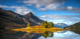 Amazingly still reflections of the island in Loch Leven, Scotland, with the Pap of Glencoe in the middle distance.