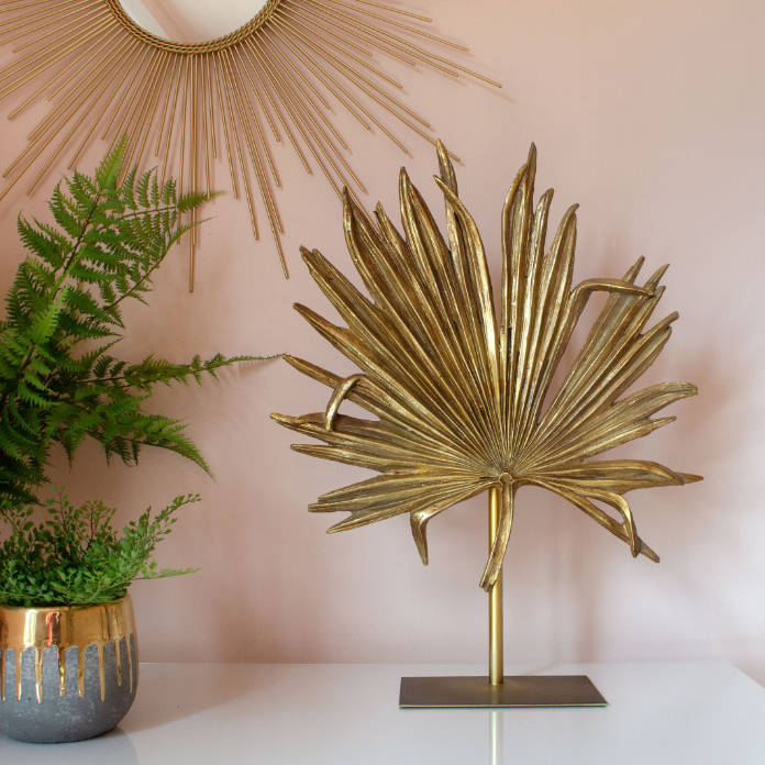 Golden Palm Leaf Ornament, £108, and Gold Sunburst Mirror, £145, Audenza