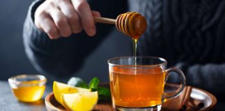 Honey drinks Cup of tea with pouring honey and lemon.