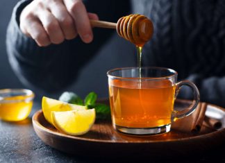 Honey drinks Cup of tea with pouring honey and lemon.