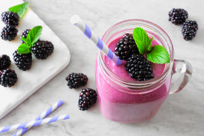 Healthy blackberry smoothie in a mason jar glass.