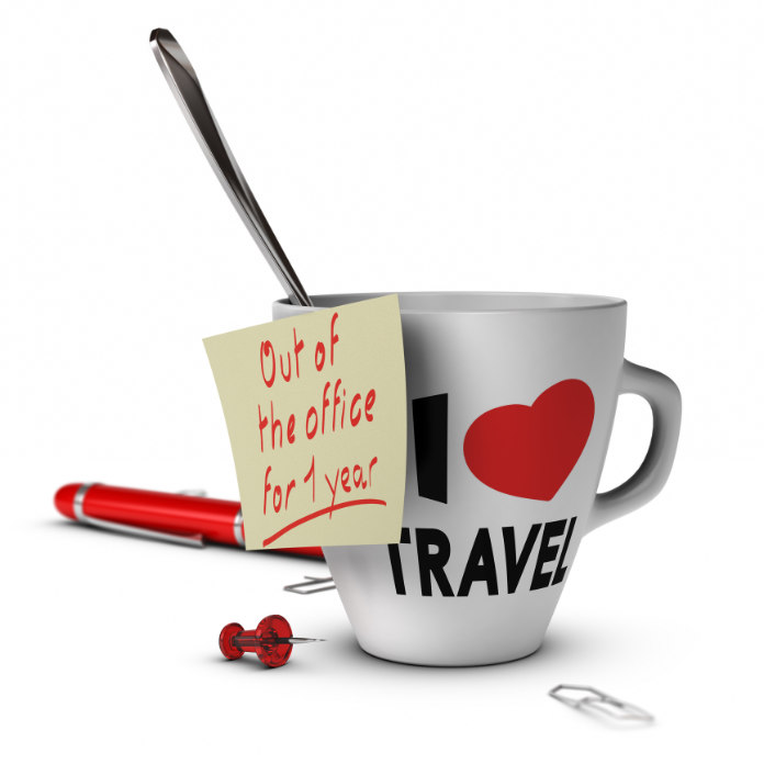 Mug with I love travel inscribed on it and a note with out of office for one year. Concept of sabbatical year.