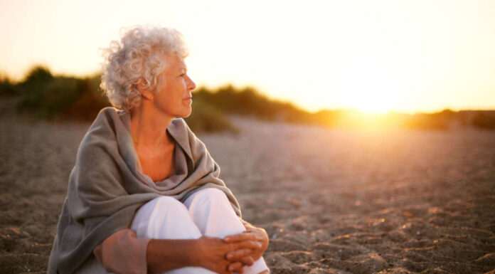 Mature woman on beach looking into horizon