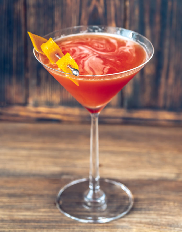 Glass of Blood And Sand Cocktail in martini glass garnished with orange peel