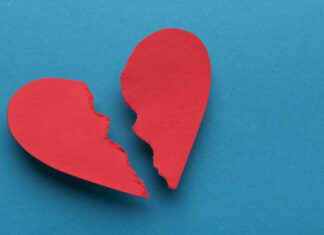 Broken paper heart on blue background