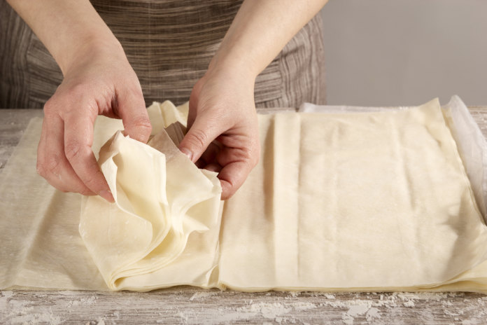 Woman separating filo pastry sheets