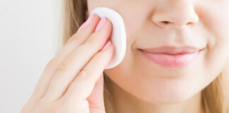 Woman using face toner on a cotton pad