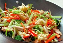 Mixed stir fry vegetables with chicken in a wok close up