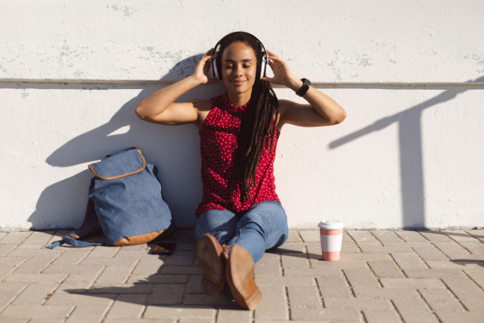 A women sitting and listening to music to deal with sleep procrastination  