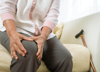 A women clutching her knee in pain due to joint pain