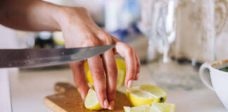 Someone cleaning a chopping board with lemon