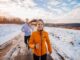 How to boost gut health- A white woman and man running outdoors on a snowy track