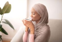 World gratitude day- Black woman in traditional hijab smelling coffee