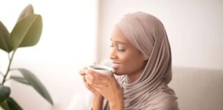 World gratitude day- Black woman in traditional hijab smelling coffee