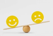 Mental health inequality- A smiley face and sad face on opposite sides of a see-saw/scale