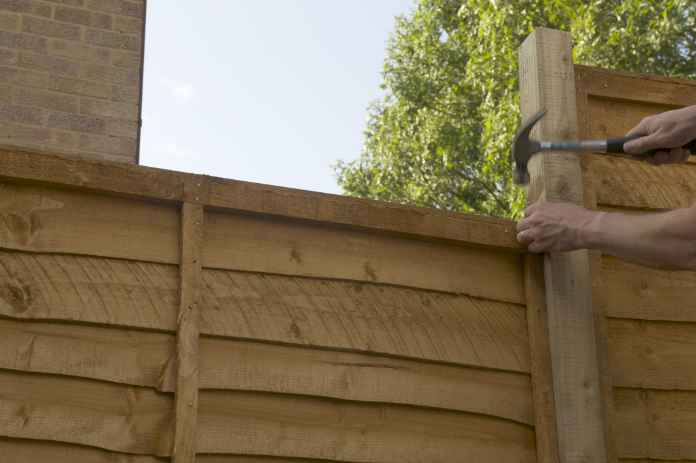 putting fence securely together with nails against post