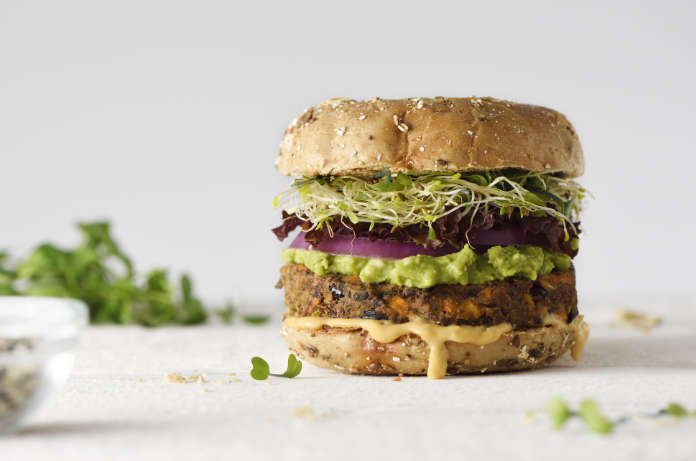 Healthy veggie burger with vegan pattie, guacamole, onion and sprout