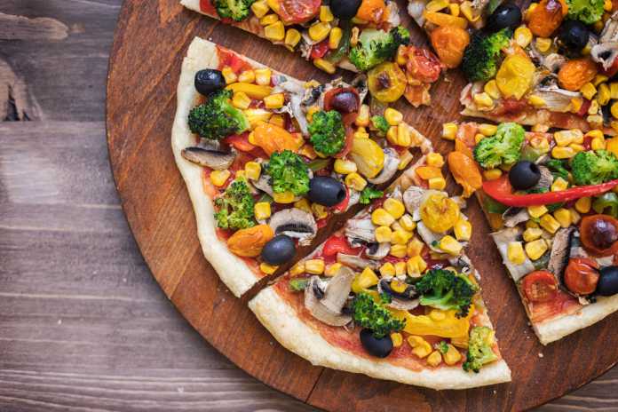 Homemade vegetarian pizza with broccoli, cherry tomato, pepper, black olives and mushrooms