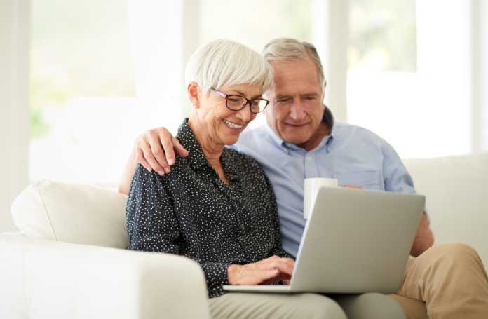 Cropped shot of an affection senior couple using their laptop while relaxing at home