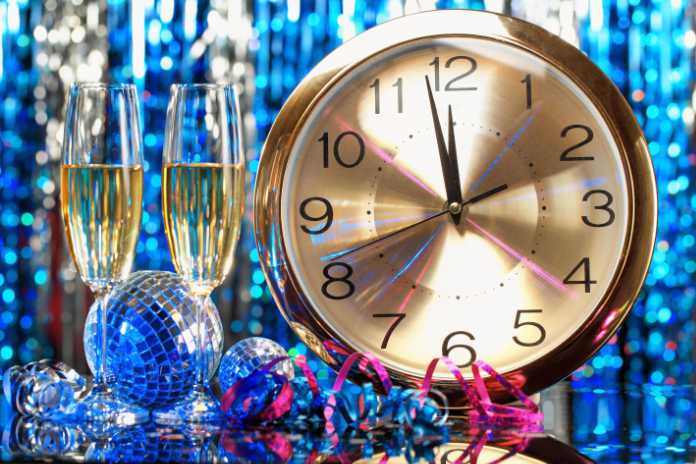 New year party decoration with champagne and clock close to midnight