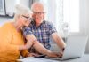 couple checking retirement plans on laptop