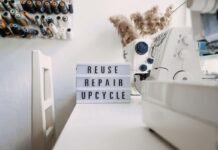 Reuse, repair, upcycle text on light board on sewing machines background