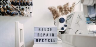 Reuse, repair, upcycle text on light board on sewing machines background