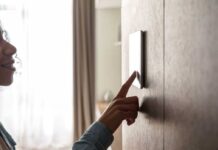 woman using smart home touch screen technology device on wall