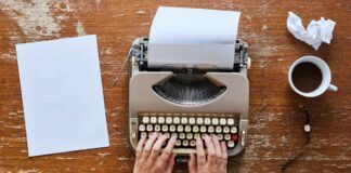 Writing retreats Hands typing on a typewriter, next to a piece of paper and cup of coffee