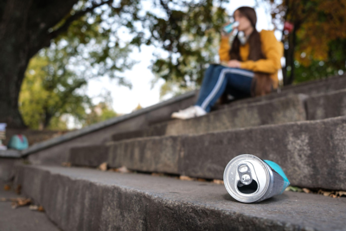A squeezed aluminum can and a teenager who drinks energy sitting on the stairs.