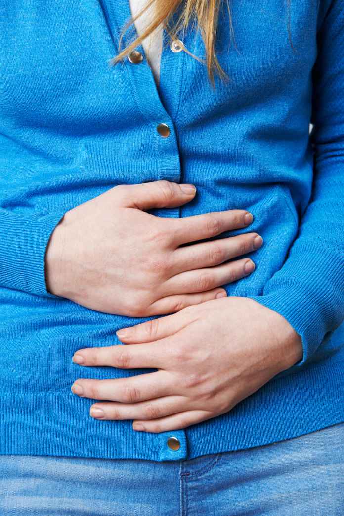 Close Up Of Woman Suffering With Stomach Pain