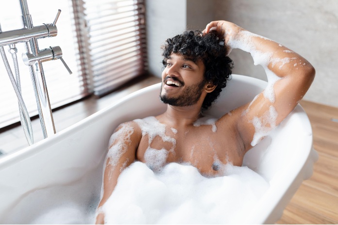 Man in bubble bath washing hair