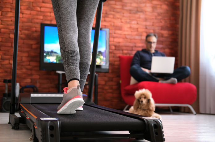 Woman using foldable treadmill at home