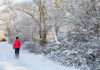 Winter walk – A woman walks along a snow covered road through a snowy, wintry